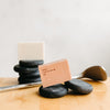 Display image of The Basic Maintenance Formula 10 Cleansing Clay bars on top of flat black rocks